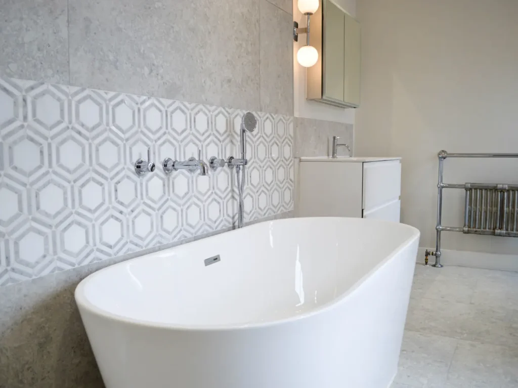 Freestanding bathtub with handheld shower in recently renovated bathroom. 