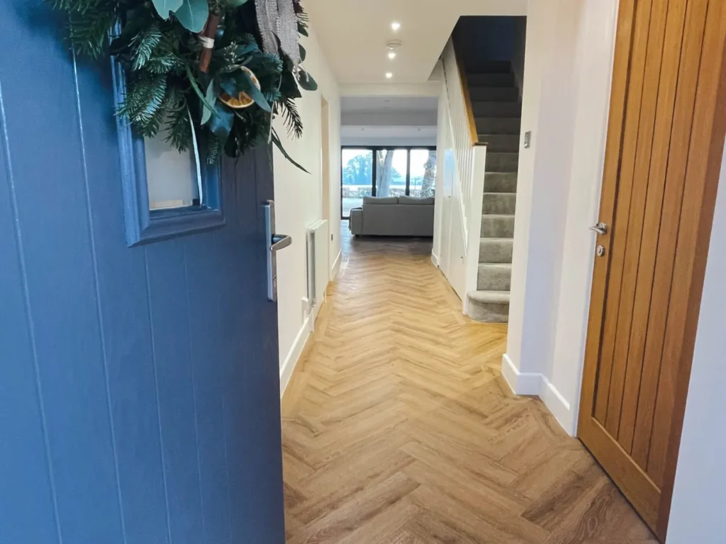 House door opening up to hallway of recently renovated home. 
