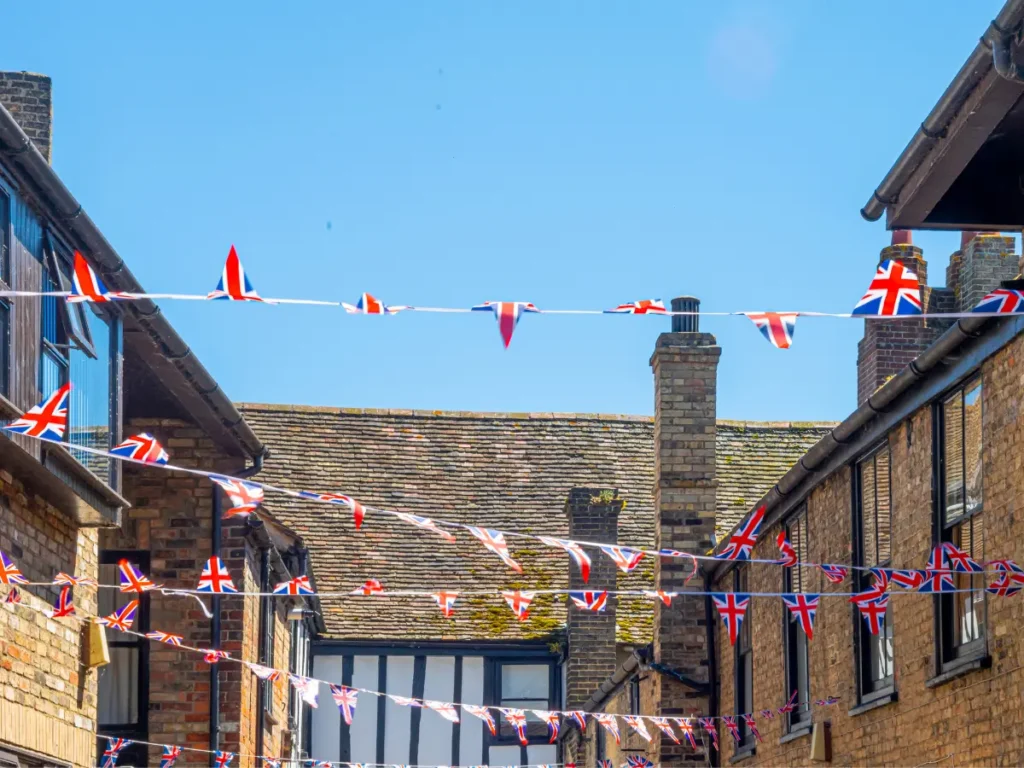 The tops of some houses in Cambridgeshire with small Union Jack flags installed over the town market. 